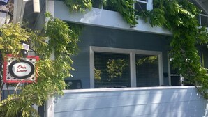 Een huis met een veranda, een bord met Oak Lawn en een raam met luiken.