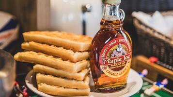 Une assiette de gaufres au sirop d’érable et une bouteille de sirop d’érable.