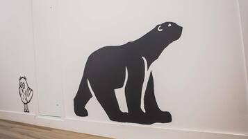Eine Wand mit einer großen, schwarzen Silhouette eines Eisbären und einer kleineren Silhouette einer Eule.