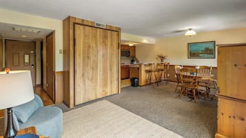 A compact living space with a kitchenette, dining area, and a door leading to another room.