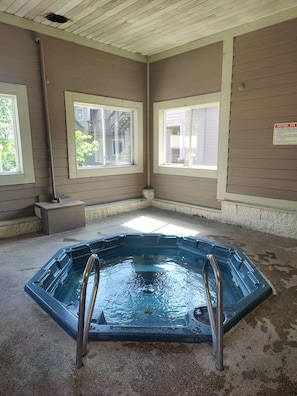 A spa room with a hot tub, windows, and a caution sign on the wall. - Hotel Nashville (Nashville)