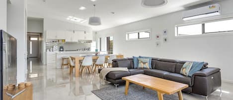 Una sala moderna con sofá, mesa de centro y comedor.