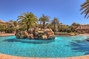 A pool with a rock feature and palm trees. - 🏝️ Seaside Therapy| 6BR | Near Resort Pool and Beach! (Destin)