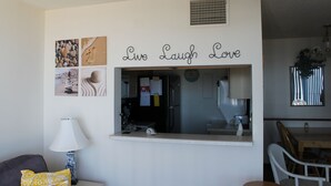 Un salón con un sofá, una lámpara y una pared con un letrero que dice 'Live Laugh Love'.