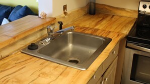 Una cocina con encimeras de madera, un lavamanos de acero inoxidable y un horno empotrado.