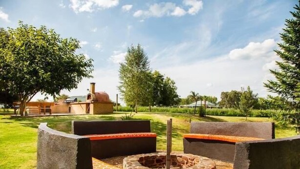 An outdoor seating area with stone benches and a fire pit. - Pizza oven; fire pit; lots of space indoor and outdoor, fires and aircon. Groups (Mudgee)