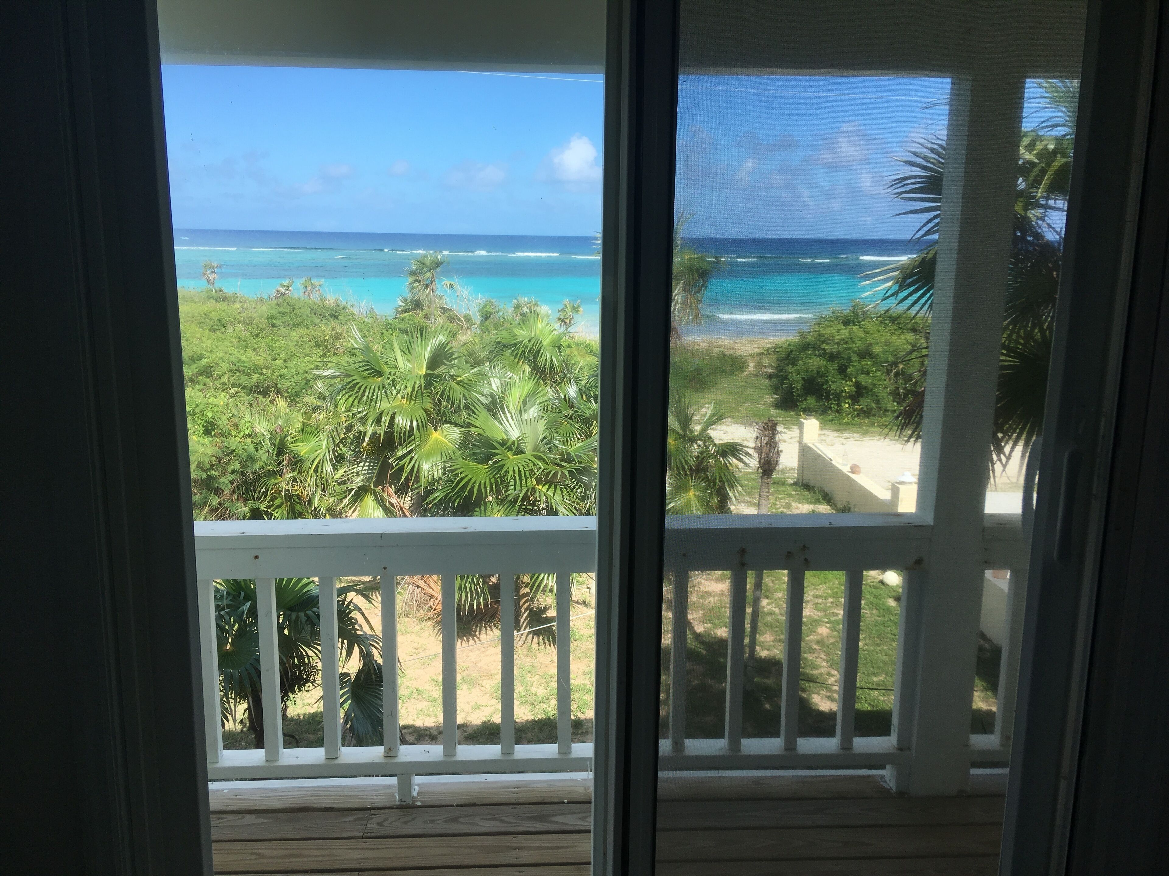 Un balcon avec vue sur l’océan et la végétation tropicale.