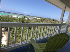 A balcony with a view of a beach and ocean.
