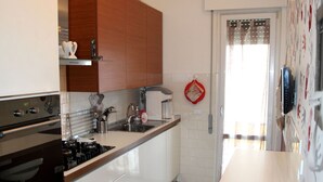 Une cuisine moderne avec des armoires blanches, une cuisinière en acier inoxydable et un plan de travail en bois.