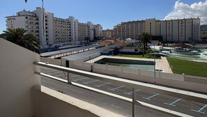 En vy över ett hotellkomplex med flera byggnader, en parkeringsplats och ett välanlagt område med en pool.