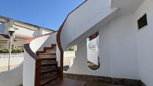 Ein weißes Gebäude mit einer Wendeltreppe, die zu einer oberen Ebene führt.
