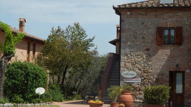 A stone building with a reception sign, surrounded by greenery and potted plants. - 45sqm two room apartment with independent entrance, kitchen living room, double bedroom (San Martino)