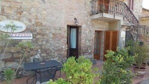 A stone building with a balcony, a table and chairs outside, and a sign that reads "Fusciaro". - 45sqm two room apartment with independent entrance, kitchen living room, double bedroom (San Martino)