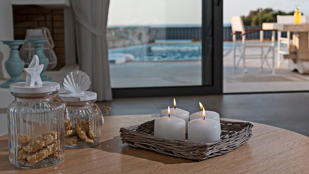 A room with a view of the sea, a fireplace, and a table with candles and decorative jars. -  Villa Levanda,pool, walking distance from the beach and shops ,no car needed! (Πάνορμος Rethymno, Crete)