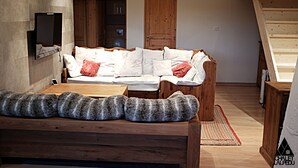 Un salón acogedor con un sofá de madera, una mesita pequeña y una alfombra mullida.