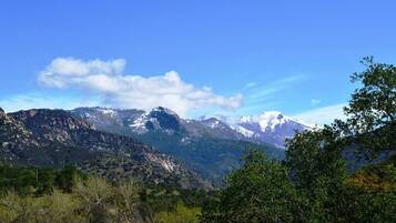A mountainous landscape with snow-capped peaks and a clear blue sky.