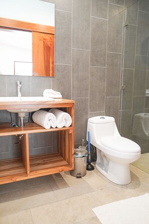 A bathroom with a wooden vanity, white sink, and toilet. - Spacious Villa Pool/Patio/Garden min from the Beach. H speed internet (Playa Santa Teresa)