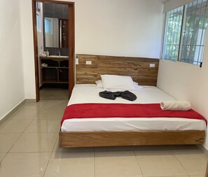 A single-bed room with a wooden headboard, a red blanket, and a white pillow. - Spacious Villa Pool/Patio/Garden min from the Beach. H speed internet (Playa Santa Teresa)
