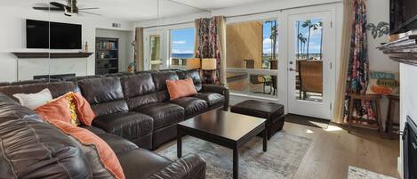 A modern living room with a leather sofa, a coffee table, and a flat-screen TV.