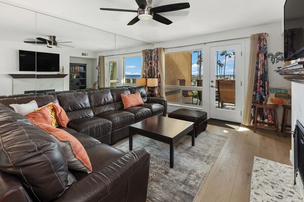 A modern living room with a leather sofa, a coffee table, and a flat-screen TV.