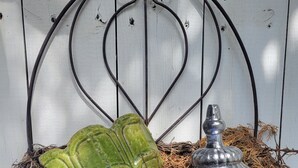 A decorative nest with a green ceramic pot, a metal vase, and twigs. - Carriage House, Forsyth Park, Pet friendly, private courtyard 🩷 (Savannah)