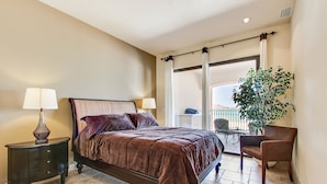 Quarto com cama, duas mesas de cabeceira, um vaso de planta e vista para o exterior.