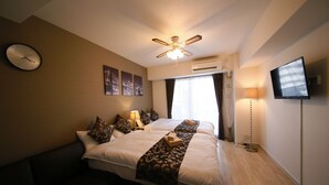 A hotel room with a bed, a ceiling fan, an air conditioning unit, a television, and a clock on the wall. - Best Residence Kujo 502 (Osaka)