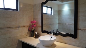 A bathroom with a white sink, a mirror, and a window. - Sunset del Mar Beach Front House (Parrita)