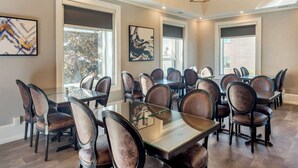 A conference room with glass tables and leather chairs, large windows, and artwork on the walls. - The Courthouse Hotel, an Ascend Collection Hotel (Thunder Bay)