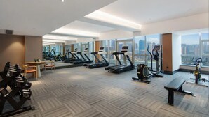 A spacious gym with treadmills, stationary bikes, and weight machines, large windows offering a city view. - Ramada by Wyndham Changsha Downtown (Changsha)