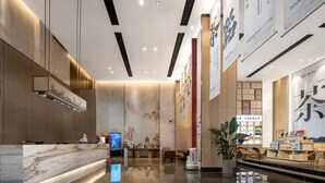 A modern hotel lobby with a reception desk, a digital screen, and a large tea shop display. - Ramada by Wyndham Changsha Downtown (Changsha)