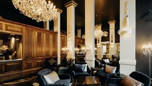 A luxurious lobby with dark wood paneling, elegant chandeliers, and plush seating areas. - Bond Street Apartment Luxury 3-bedroom (Dunedin)