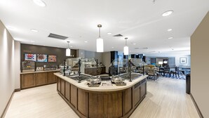 A modern kitchen area with a central island, built-in appliances, and a seating area with tables and chairs. - Staybridge Suites Naples – Marco Island by IHG (Naples)