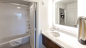 A bathroom with a bathtub, a sink, and a mirror.