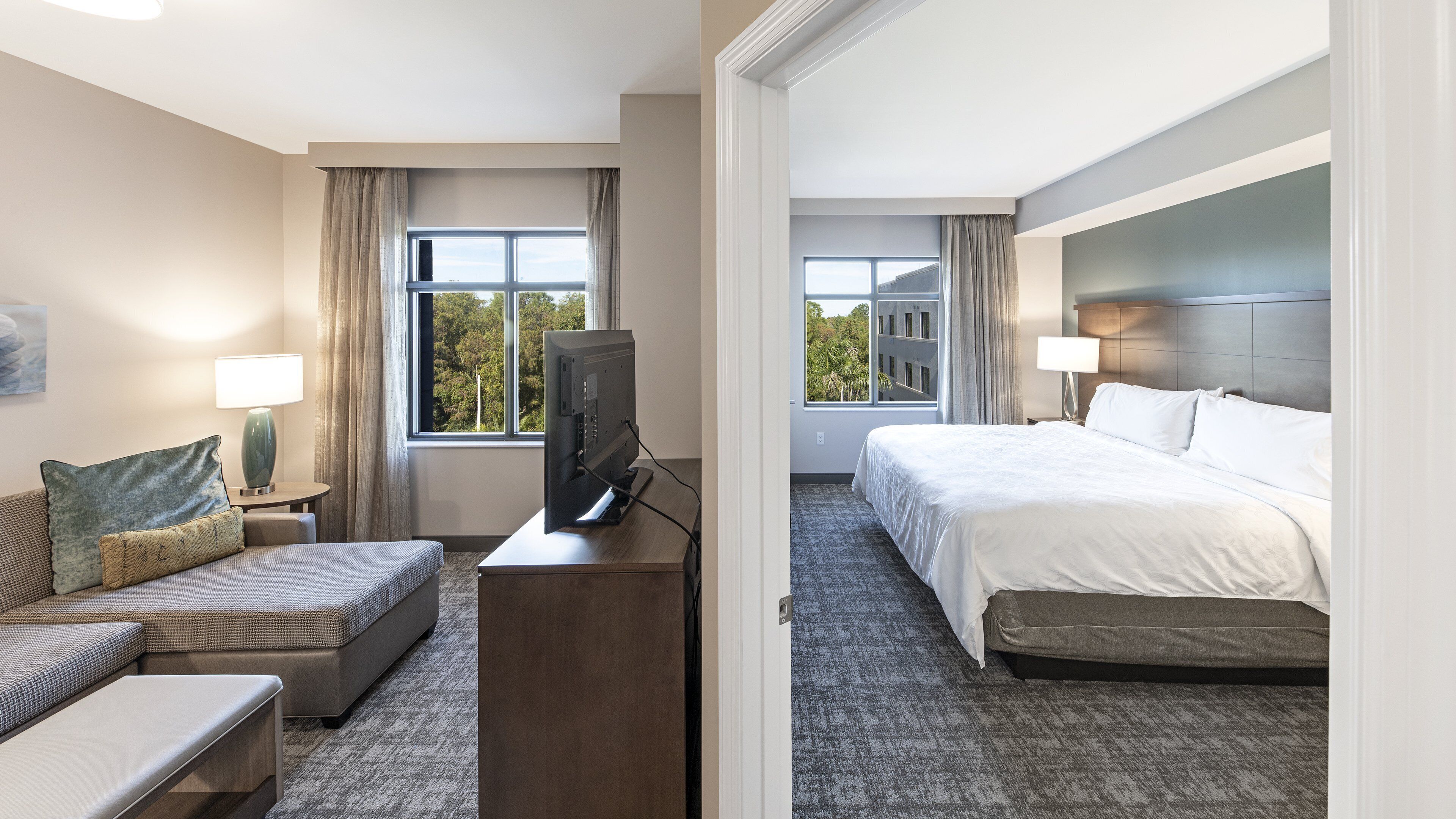 Une chambre d’hôtel avec un lit, une télévision, un canapé et un bureau.