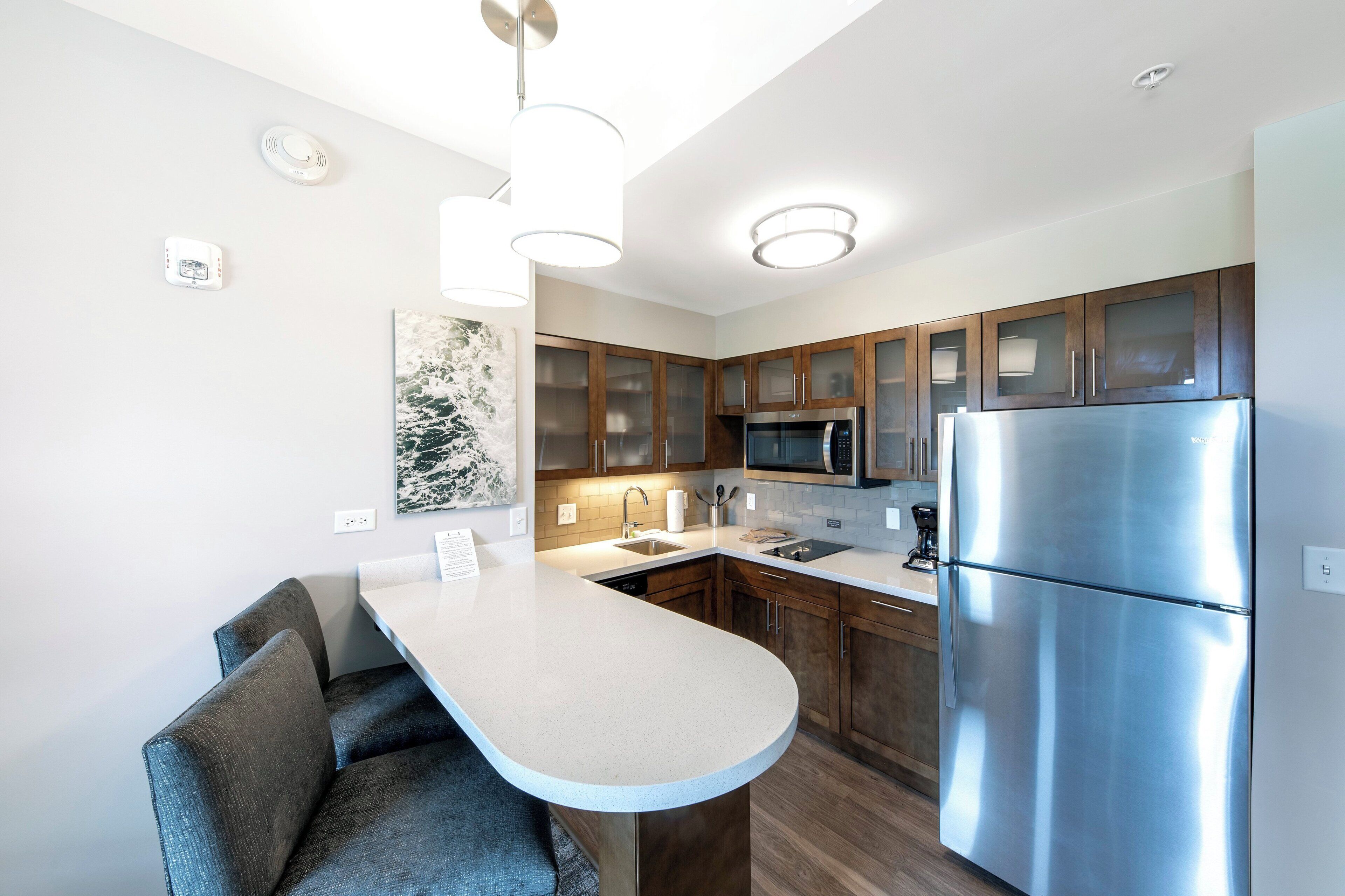 A modern kitchen with a central island, stainless steel appliances, and wooden cabinets.