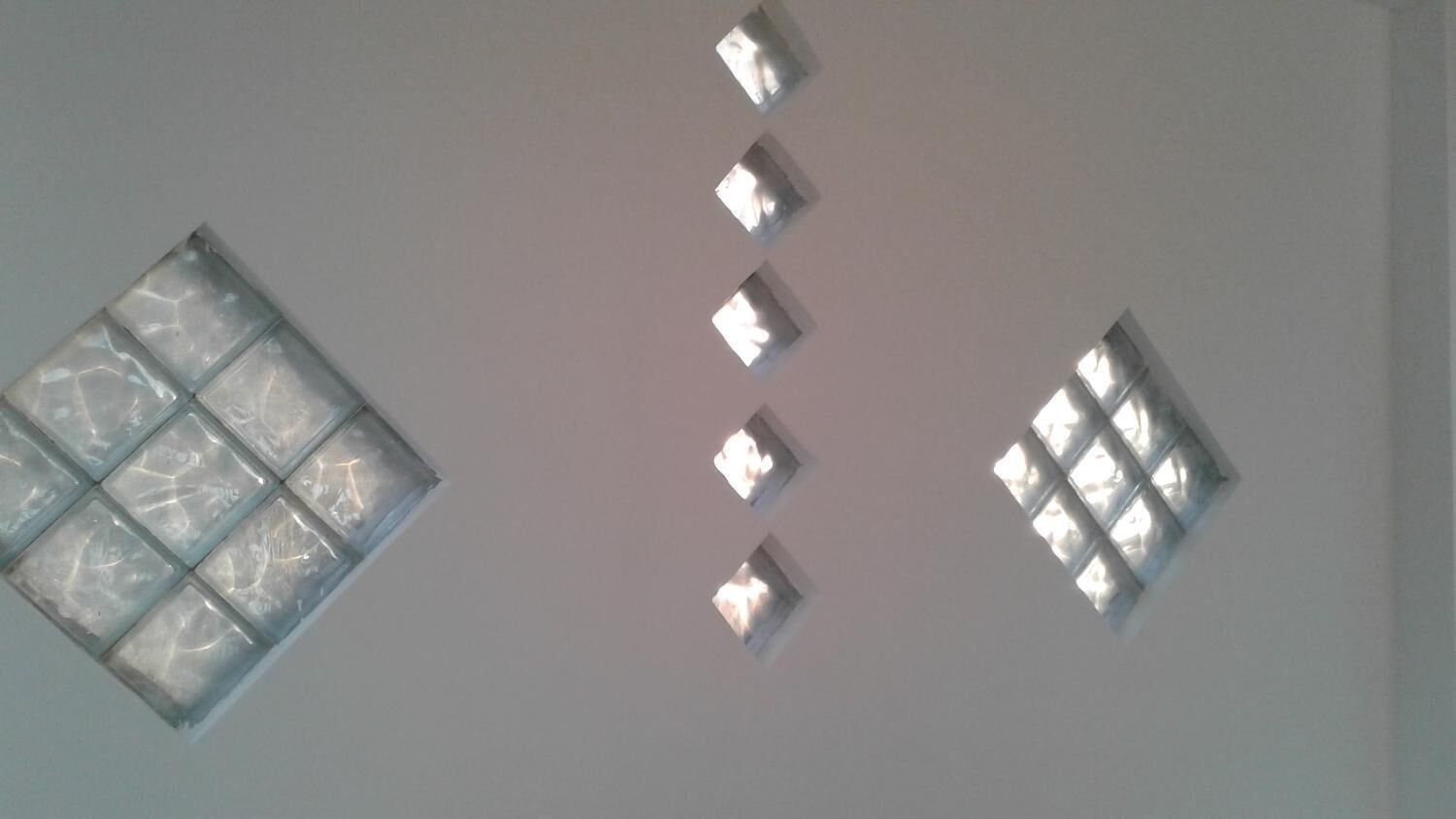 Eine Decke mit einer Reihe quadratischer Fenster und einem größeren Fenster mit Gitterstruktur.