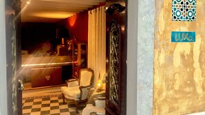 A hotel lobby with a checkered floor, a reception desk, and a decorative door. - LUXa Charmhouse Hotel (Sintra)