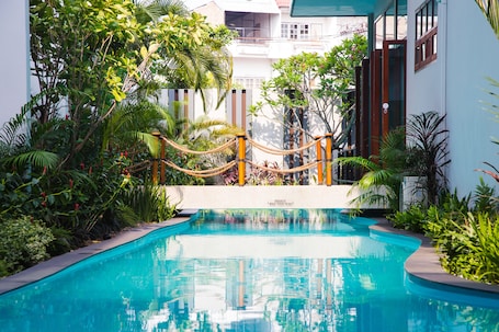 Una piscina al aire libre, sillones reclinables de piscina