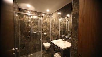 Suíte, 1 quarto | Banheiro | Chuveiro, chuveiro com efeito de chuva, produtos de toalete grátis