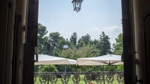 An open doorway leading to an outdoor area with a wrought iron gate, a bench, and a lamp post. - Tenuta Villa Colle Sereno (Montemarciano)