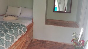 A bedroom with a bed, pillows, a wooden headboard, a mirror, and a small wooden shelf. - Sincere Wilderness (Nuwara Eliya)