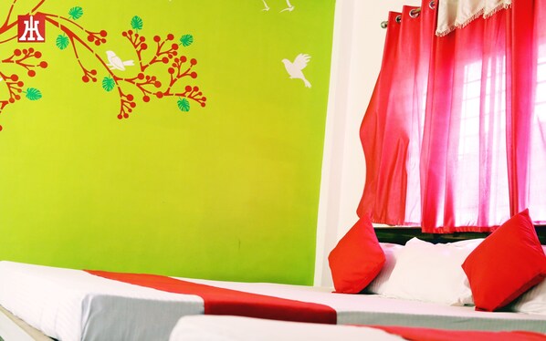 Une pièce avec un mur vert, des rideaux rouges et un lit avec une literie blanche et rouge.
