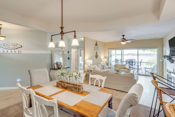 Relax in this inviting living area with a dining table for four, comfortable seating, and a ceiling fan.