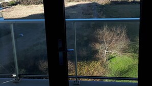 Uitzicht vanaf een balkon op een strand met een heldere lucht.