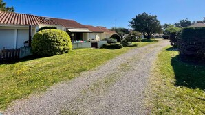 A residential area with a gravel driveway leading to a house with a tiled roof. - Cozy House Near Dunes Beach, 2 Bedrooms + Mezzanine, Parking & Garden, Baby Gear Included (Bretignolles-sur-Mer)