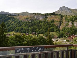 Paesaggio montano con chalet in legno immersi tra gli alberi.