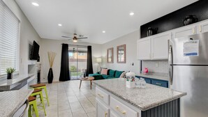 A modern kitchen with a central island, white cabinetry, and stainless steel appliances. - Near Las Vegas Strip and Airport: Games & Arcades- Southpoint less than 5 mins. (Las Vegas)