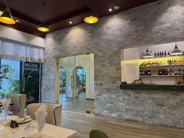 A restaurant interior with a bar area, wooden flooring, and a brick wall.