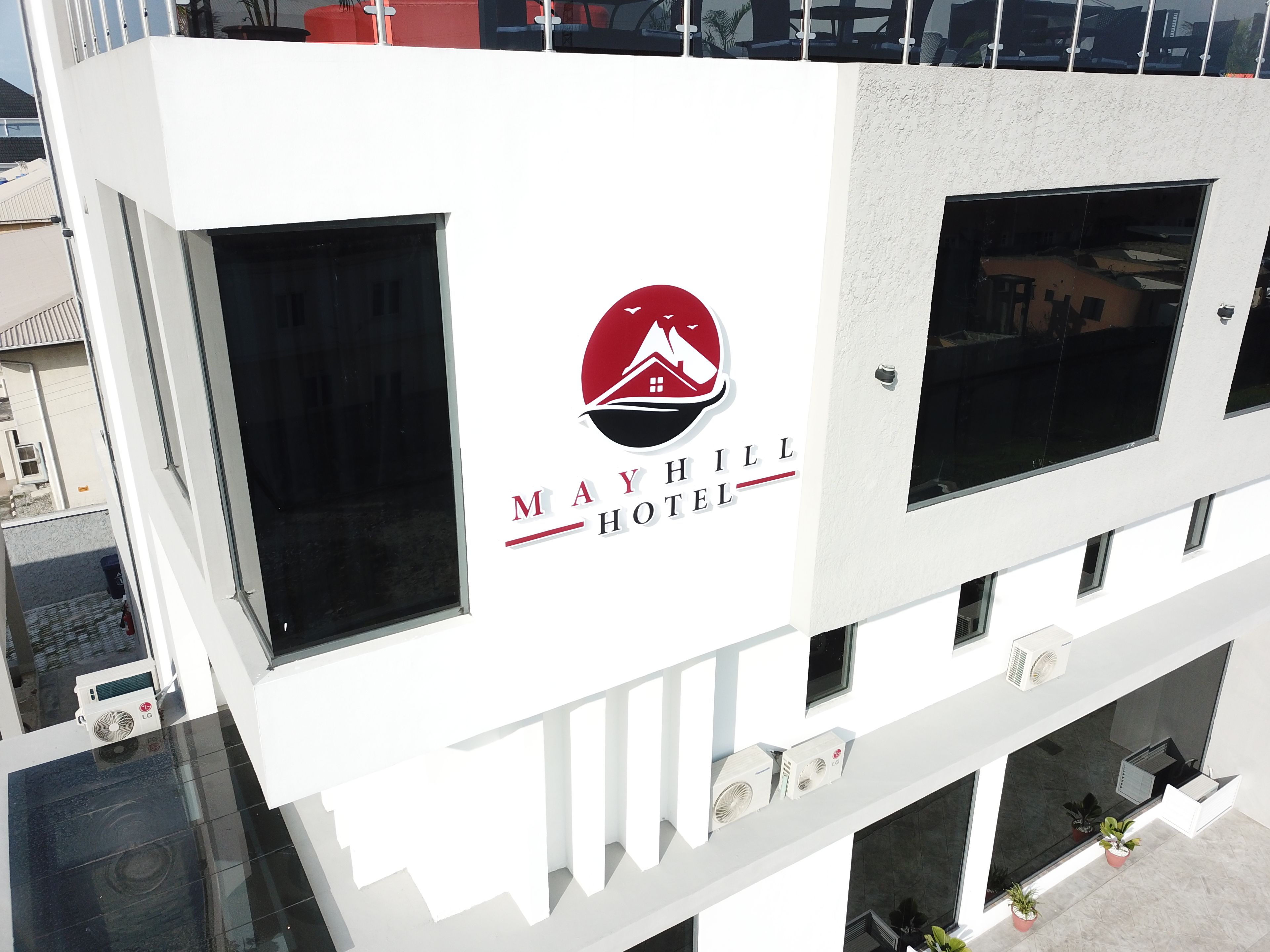 Un cartel de hotel con un logotipo y el nombre 'Mayhill Hotel'.